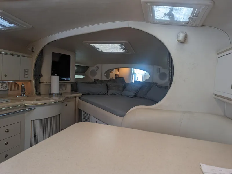 Slide: The Image of Interior of 2000 Sea Ray 310 Sundancer yacht with cozy seating and kitchenette. - 7