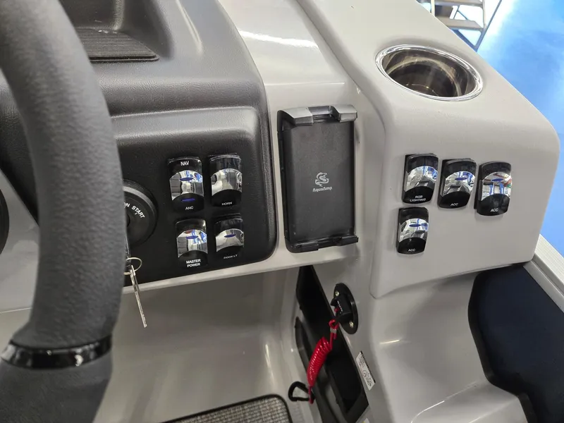 Slide: The Image of Dashboard of 2025 Harris Cruiser 210 boat with control switches and cup holder. - 17