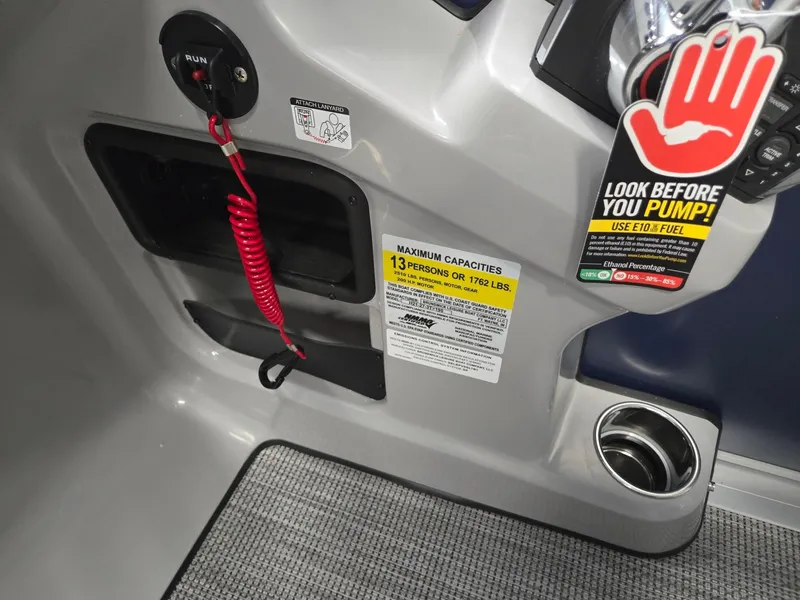 Slide: The Image of 2025 Harris Cruiser 210 boat dashboard with safety warnings and capacity label. - 18