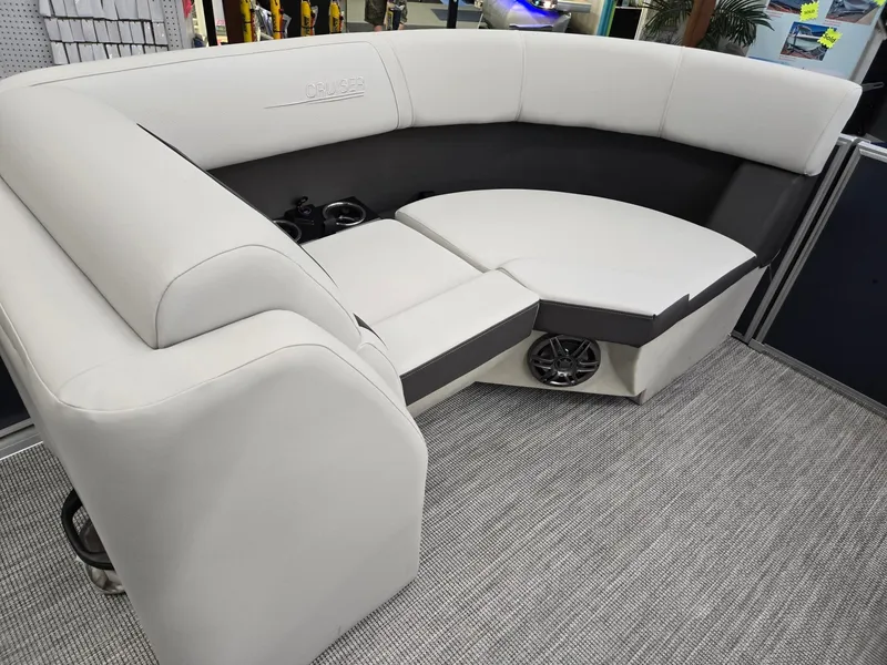 Slide: The Image of 2025 Harris Cruiser 210 boat interior with plush seating and integrated speakers. - 34