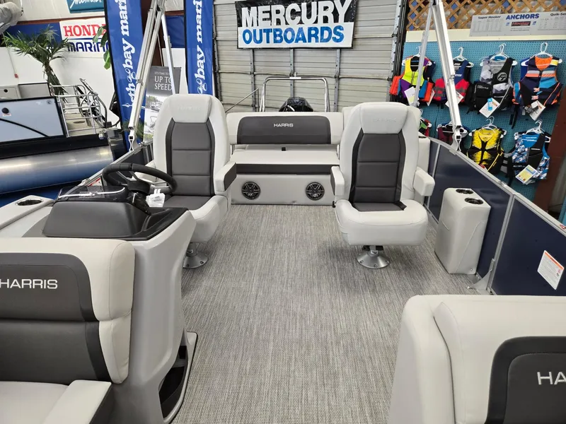 Slide: The Image of 2025 Harris Cruiser 210 pontoon boat interior with gray seating and Mercury Outboards signage. - 8