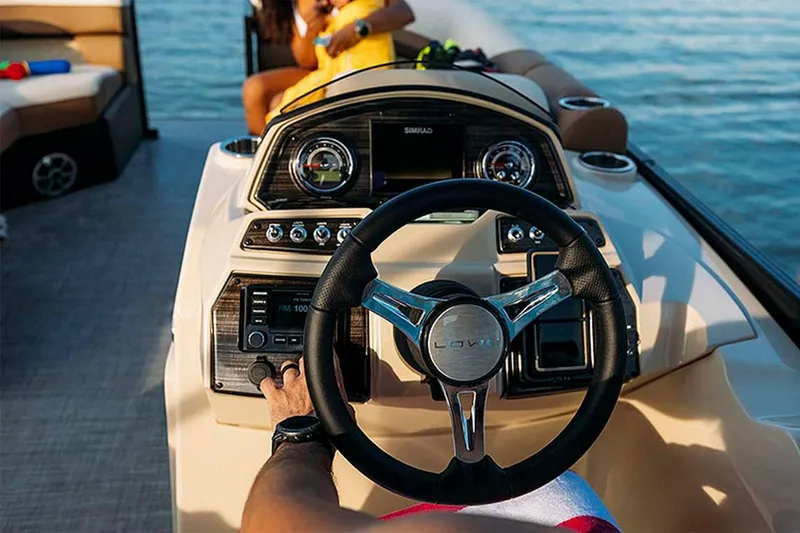 Slide: The Image of 2024 Lowe SS 210 WT boat dashboard with steering wheel and controls on water. - 10
