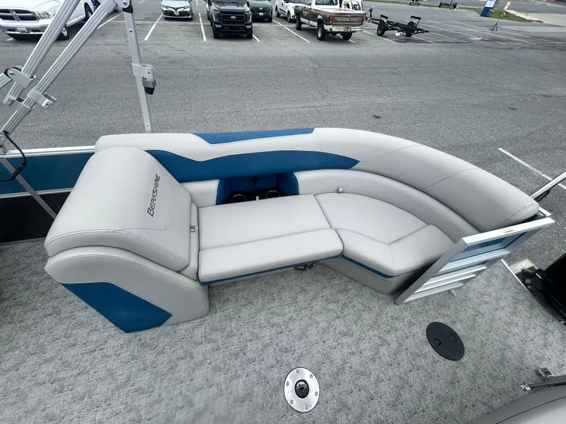Slide: The Image of 2024 Berkshire 24RFX LE 2.75 pontoon boat with gray and blue seating in a parking lot. - 11