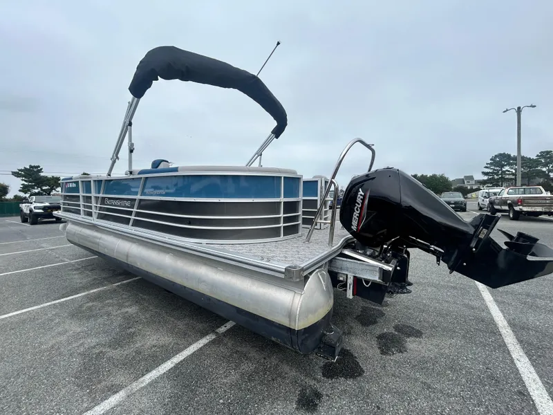 Slide: The Image of 2024 Berkshire 24RFX LE 2.75 pontoon boat with Mercury outboard motor in parking lot. - 15