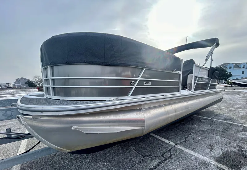 Slide: The Image of 2024 Berkshire 24RFX LE 2.75 pontoon boat parked on a paved surface. - 2