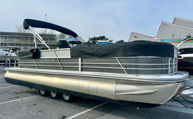 Slide: The Image of 2024 Berkshire 24RFX LE 2.75 pontoon boat with cover in a parking lot. - 6