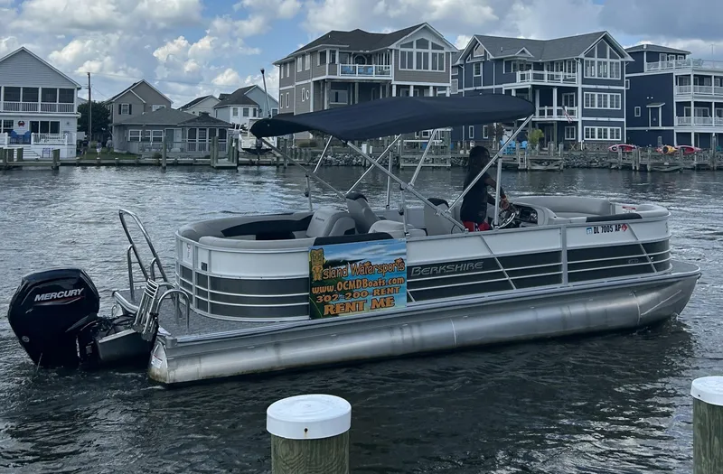 Slide: The Image of 2024 Berkshire 24RFX LE 2.75 pontoon boat on water, docked near waterfront homes. - 8