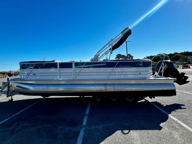 Slide: The Image of 2024 Berkshire 24RFX LE 2.75 pontoon boat parked in a sunny lot. - 2