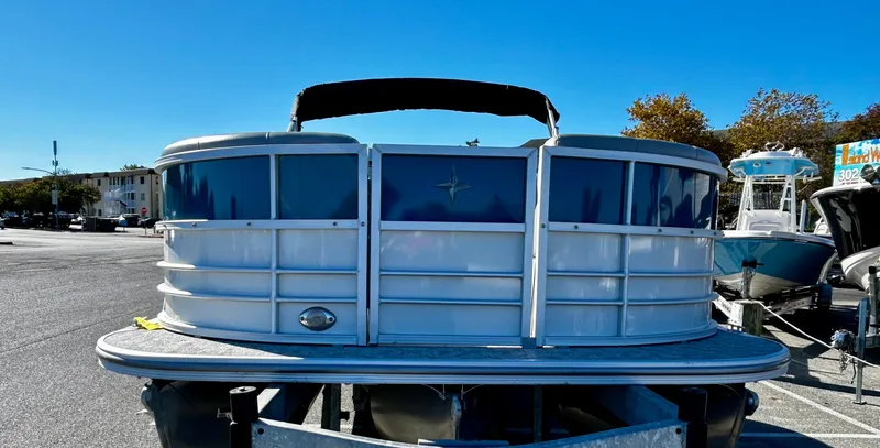 Slide: The Image of 2024 Berkshire 24RFX LE 2.75 pontoon boat on trailer, parked outdoors. - 3