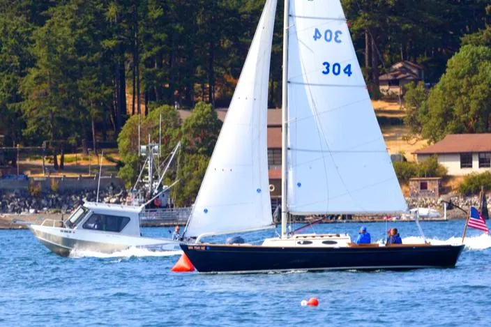 The Image of Sailboat and motorboat on a scenic lake with forested shoreline, 2005 Express Alerion. - 0