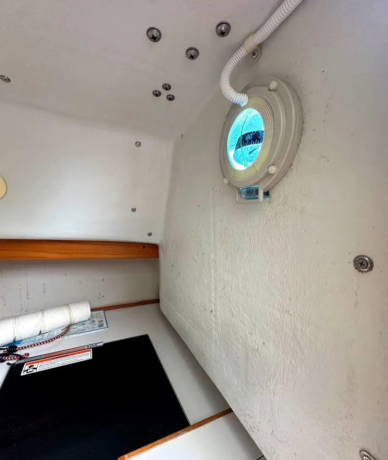 Slide: The Image of Interior cabin of 2005 Express Alerion sailboat with porthole and wooden accents. - 12