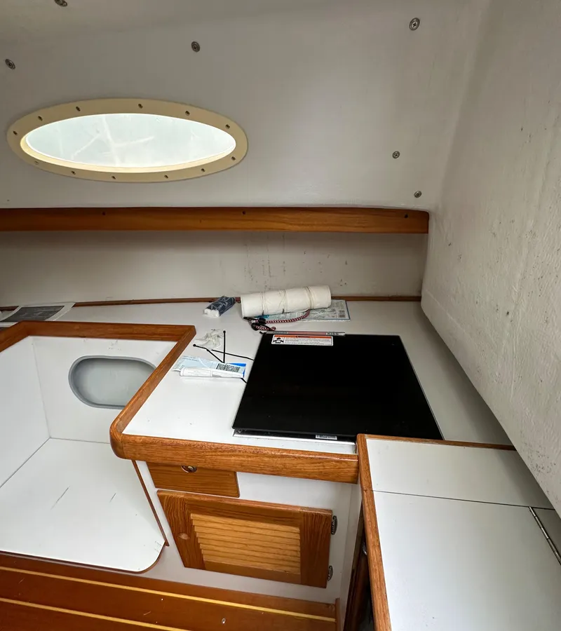 Slide: The Image of 2005 Express Alerion cabin interior with wooden trim and porthole window. - 13