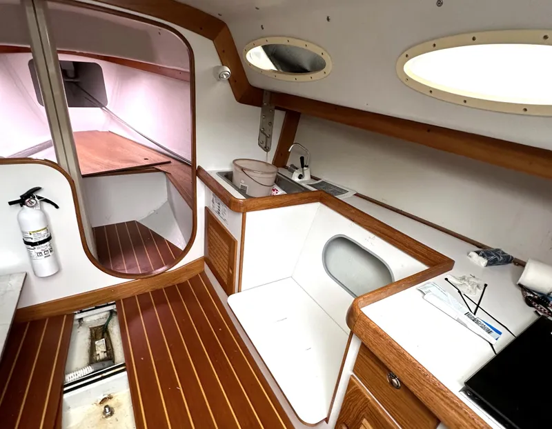 Slide: The Image of Interior of a 2005 Express Alerion sailboat with wood accents and compact kitchen area. - 14
