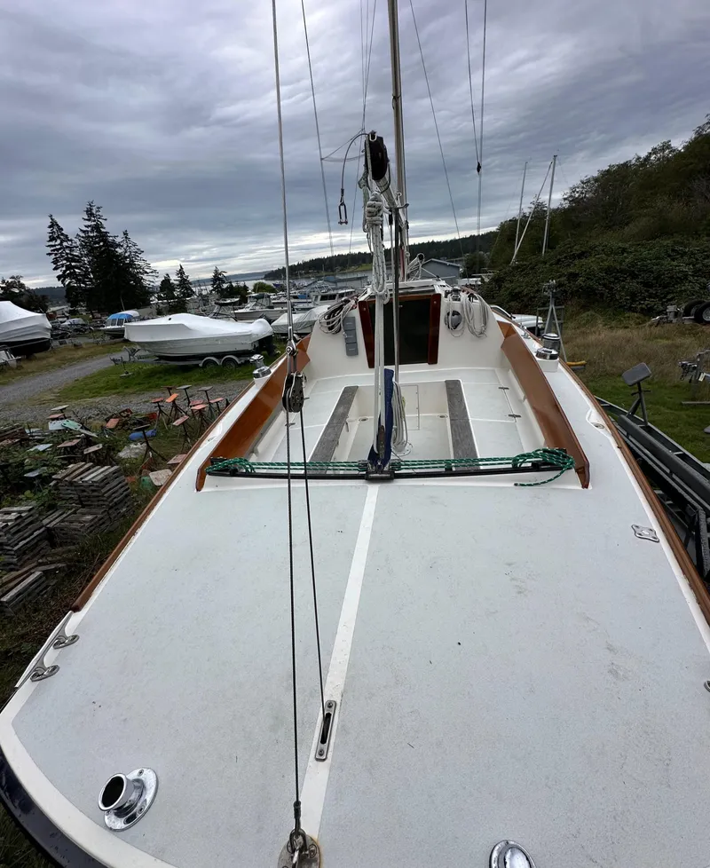 Slide: The Image of 2005 Express Alerion sailboat on land, cloudy sky, surrounded by trees and other boats. - 22