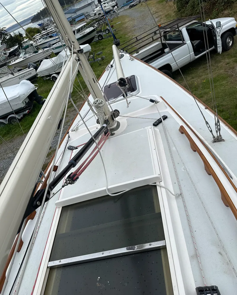 Slide: The Image of 2005 Express Alerion sailboat deck with mast, docked near a white truck. - 25