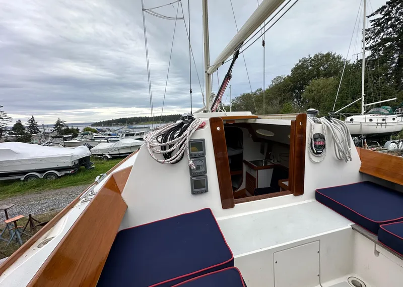 Slide: The Image of 2005 Express Alerion sailboat cockpit with navy cushions, docked in a marina. - 31