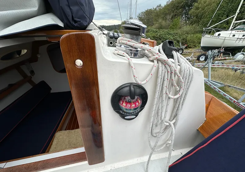 Slide: The Image of 2005 Express Alerion sailboat cockpit with ropes and compass, docked outdoors. - 32