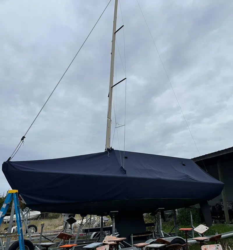 Slide: The Image of 2005 Express Alerion sailboat covered, docked under cloudy sky. - 6
