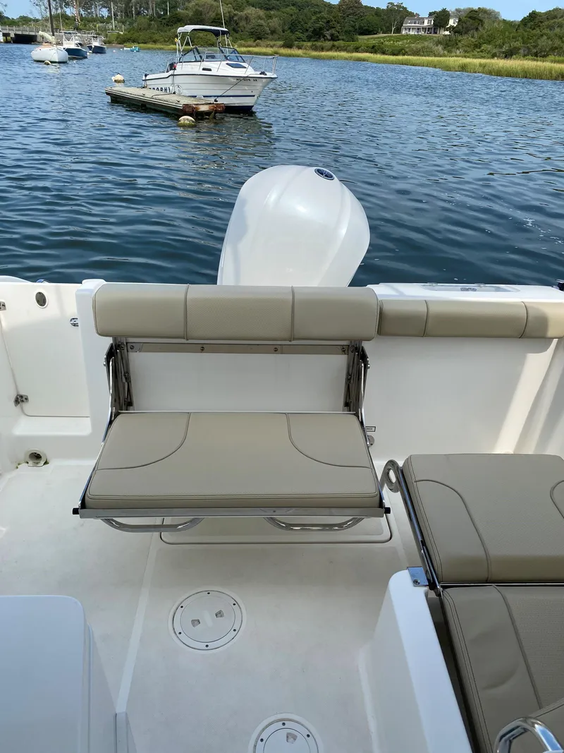 Slide: The Image of 2021 Pursuit DC 235 Dual Console boat with seating, on a calm lake. - 20