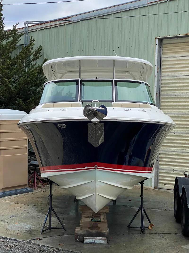 Slide: The Image of 2021 Pursuit DC 235 Dual Console boat on stands, front view, in storage. - 5