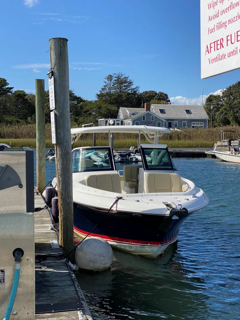 Slide: The Image of 2021 Pursuit DC 235 Dual Console boat docked at a marina on a sunny day. - 6