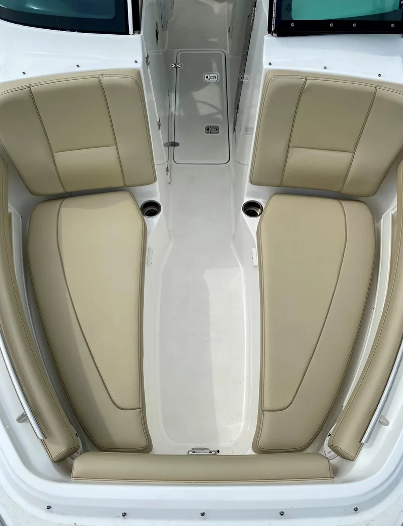 Slide: The Image of 2021 Pursuit DC 235 Dual Console boat interior with beige seating. - 9