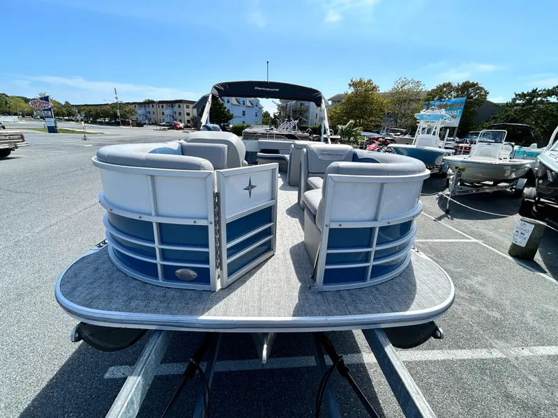 Slide: The Image of 2024 Berkshire 24CL LE 2.75 pontoon boat in a parking lot, showcasing spacious seating. - 2
