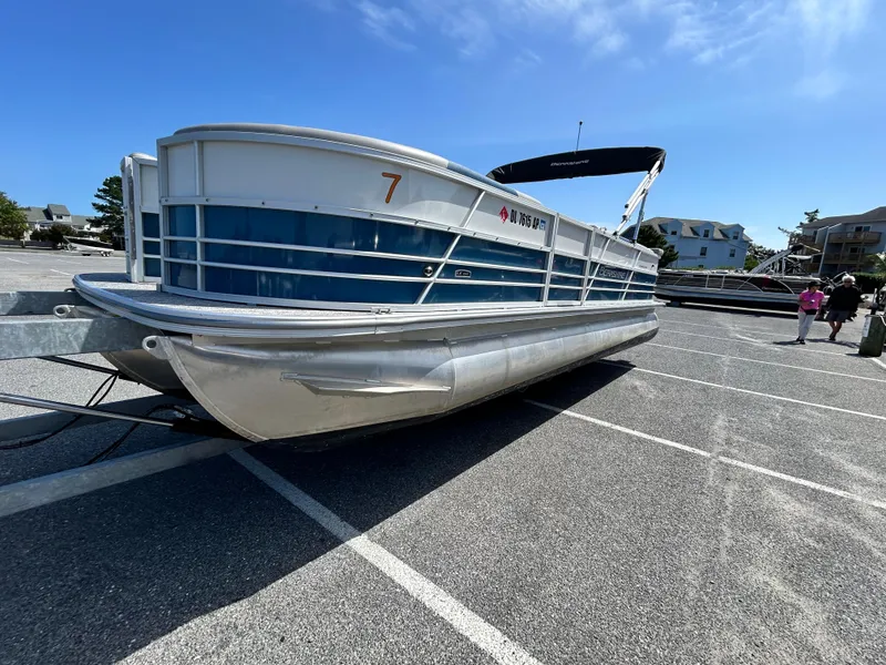 Slide: The Image of 2024 Berkshire 24CL LE 2.75 pontoon boat parked on asphalt under clear blue sky. - 3
