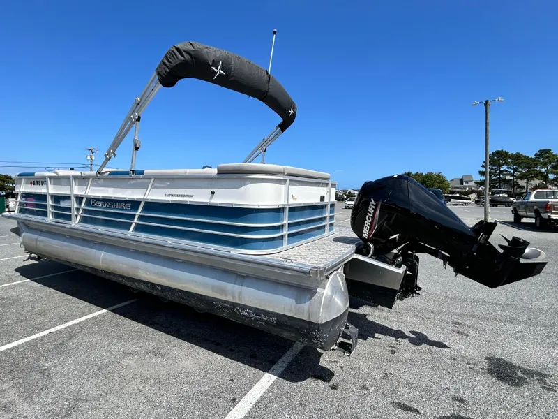 Slide: The Image of 2024 Berkshire 24CL LE 2.75 pontoon boat with canopy and outboard motor in parking lot. - 5