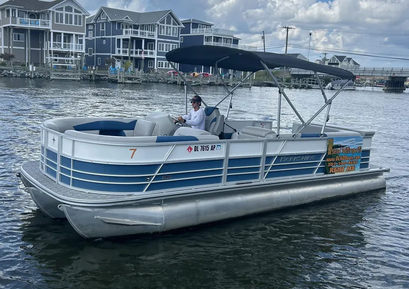 Slide: The Image of 2024 Berkshire 24CL LE 2.75 pontoon boat on water near coastal homes. - 9