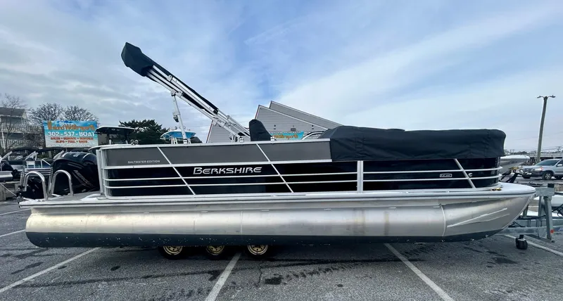 The Image of 2024 Berkshire 24CL LE 2.75 pontoon boat parked on a lot under a cloudy sky. - 0