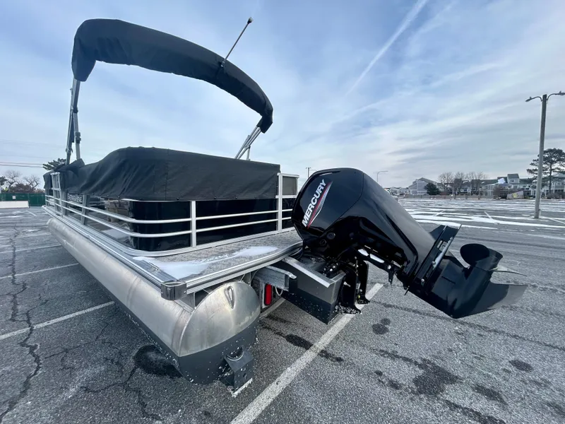 Slide: The Image of 2024 Berkshire 24CL LE 2.75 pontoon boat with Mercury outboard motor in parking lot. - 2