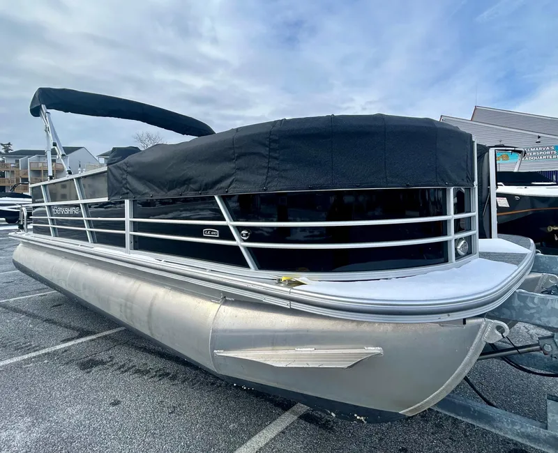 Slide: The Image of 2024 Berkshire 24CL LE 2.75 pontoon boat with black cover, parked outdoors. - 4