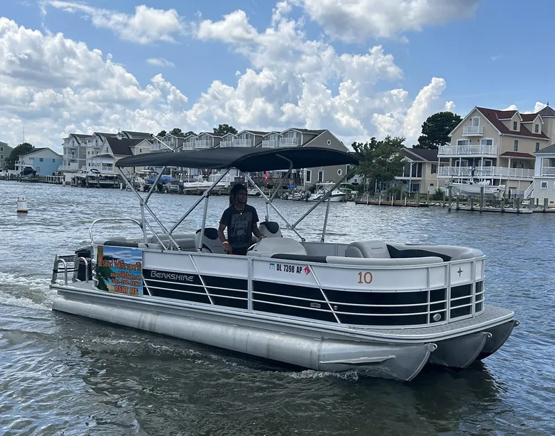 Slide: The Image of 2024 Berkshire 24RFX LE 2.75 pontoon boat cruising on a scenic lake. - 18