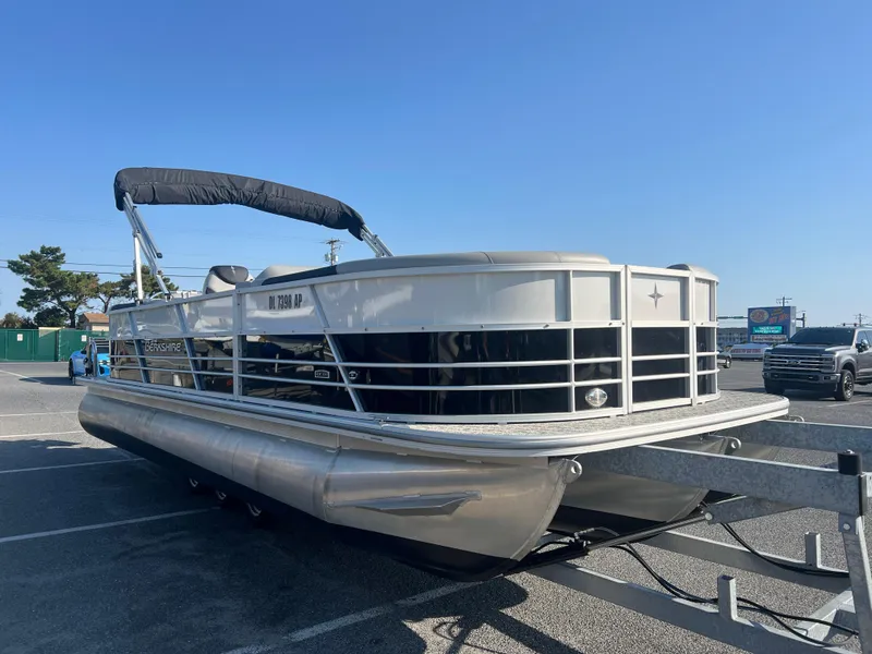 Slide: The Image of 2024 Berkshire 24RFX LE 2.75 pontoon boat on trailer in parking lot. - 2