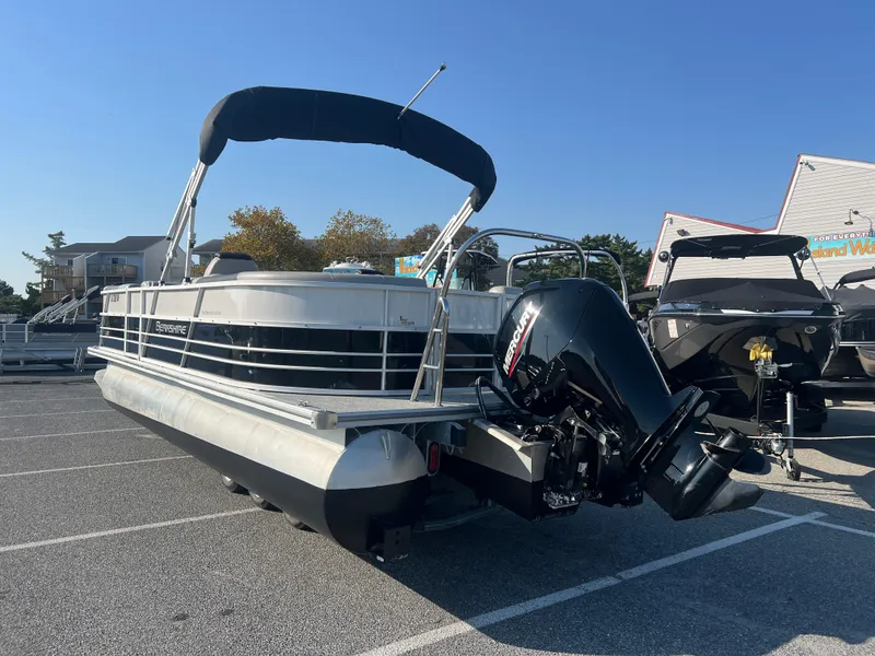 Slide: The Image of 2024 Berkshire 24RFX LE 2.75 pontoon boat with outboard motor in parking lot. - 3