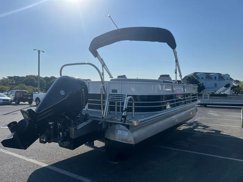 Slide: The Image of 2024 Berkshire 24RFX LE 2.75 pontoon boat with canopy and outboard motor in a parking lot. - 4