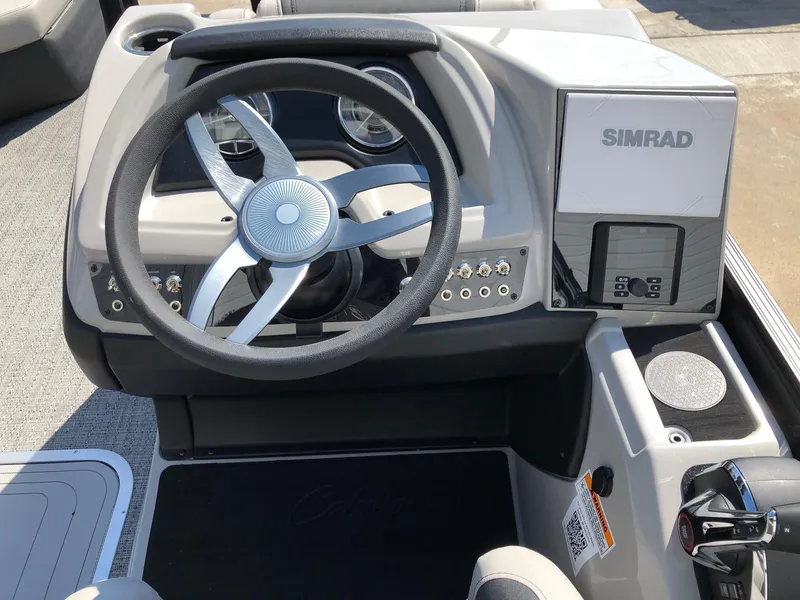 Slide: The Image of 2025 Barletta Cabrio 22QC boat dashboard with steering wheel and Simrad display. - 9