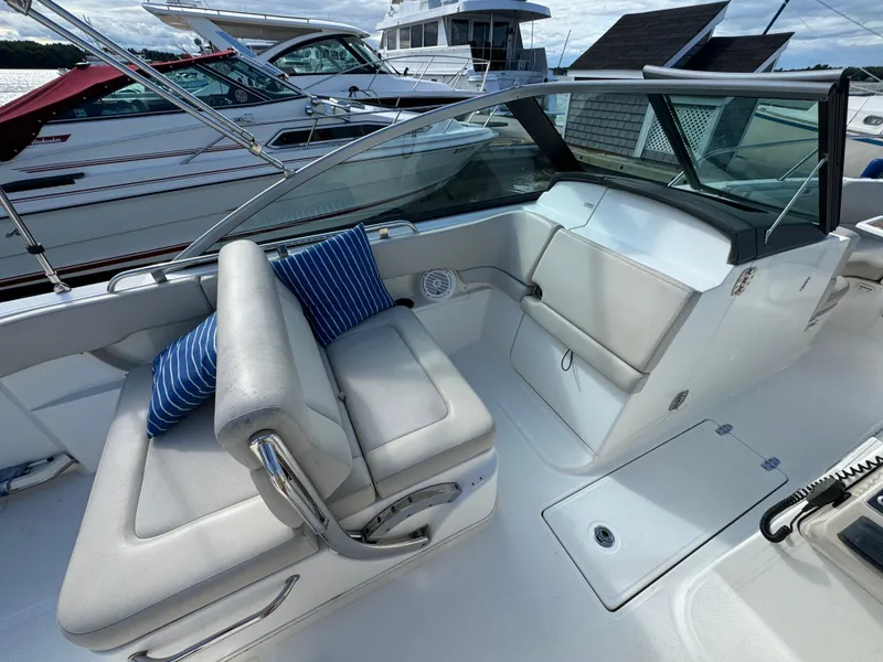 Slide: The Image of 2013 Boston Whaler 270 Vantage boat interior with cushioned seating and striped pillow. - 11