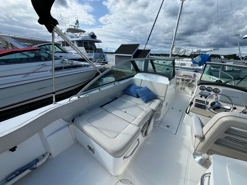 Slide: The Image of 2013 Boston Whaler 270 Vantage boat interior with seating and dashboard, docked at marina. - 12