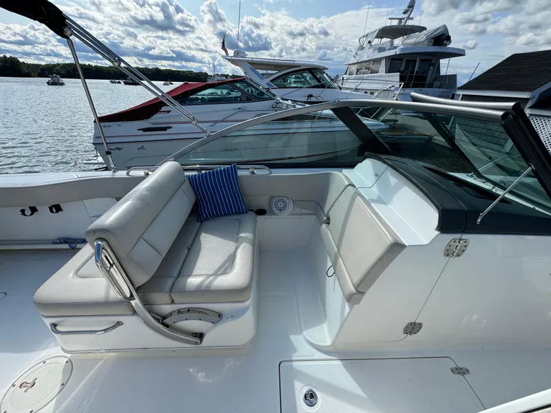 Slide: The Image of 2013 Boston Whaler 270 Vantage boat interior with seating, docked by the water. - 13