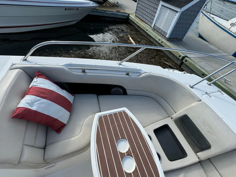 Slide: The Image of Boston Whaler 270 Vantage 2013 boat interior with striped cushion and wooden table. - 19