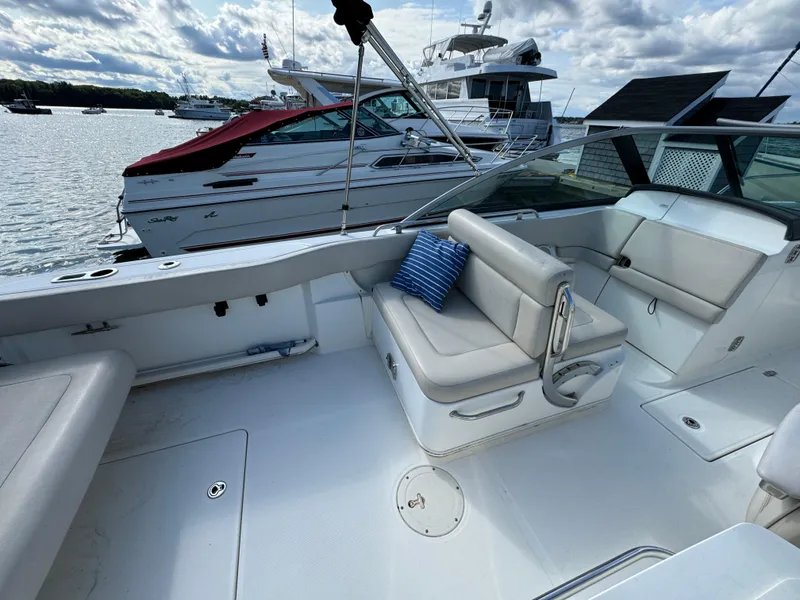 Slide: The Image of 2013 Boston Whaler 270 Vantage boat interior with seating, docked near other boats. - 9