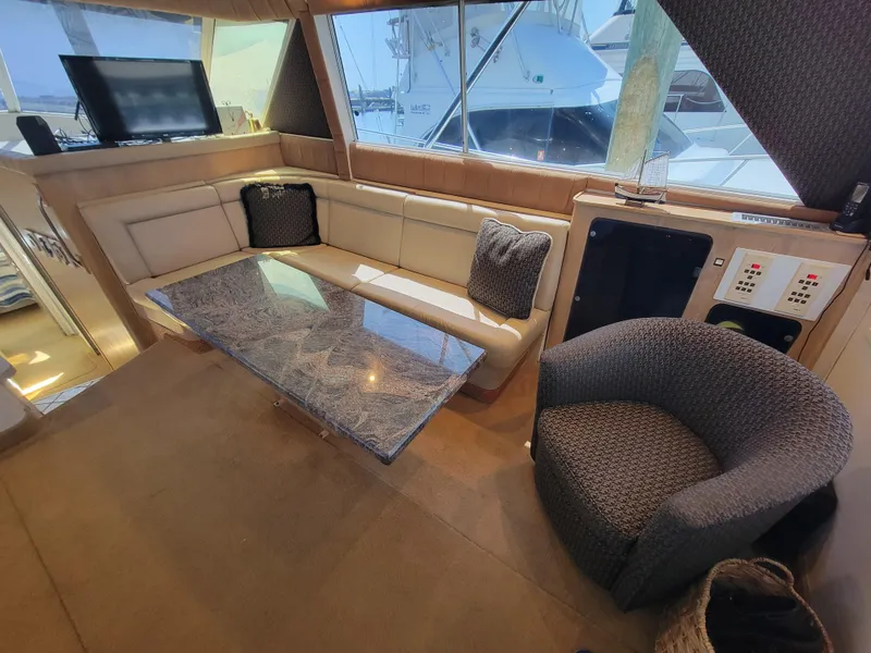 Slide: The Image of 1989 Trojan 46 Sportfish interior with plush seating, glass table, and modern amenities. - 11