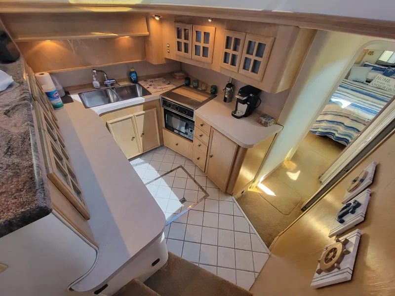 Slide: The Image of 1989 Trojan 46 Sportfish yacht kitchen with modern appliances and cozy interior design. - 14