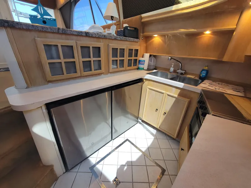 Slide: The Image of 1989 Trojan 46 Sportfish yacht kitchen with modern appliances and wooden cabinetry. - 15