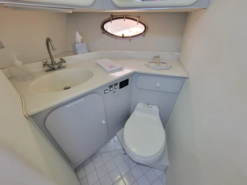 Slide: The Image of 1989 Trojan 46 Sportfish yacht bathroom with sink, toilet, and porthole window. - 21