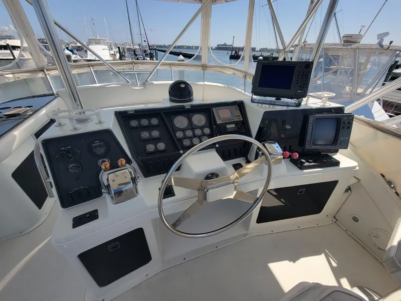 Slide: The Image of 1989 Trojan 46 Sportfish helm with steering wheel, gauges, and navigation equipment. - 23