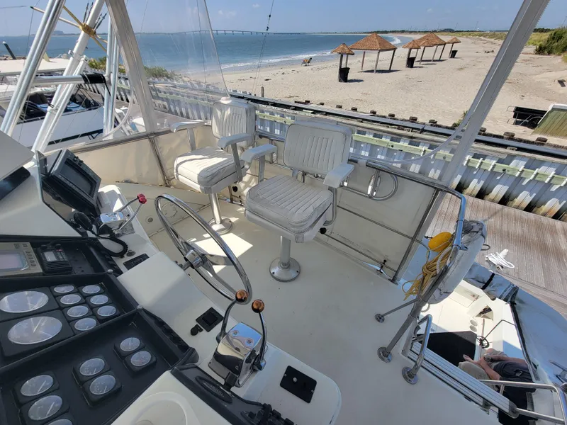Slide: The Image of 1989 Trojan 46 Sportfish yacht helm with ocean view and beach in background. - 26