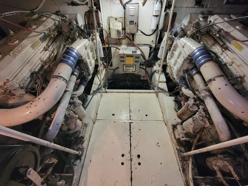 Slide: The Image of Engine room of a 1989 Trojan 46 Sportfish boat, featuring dual engines and mechanical components. - 27